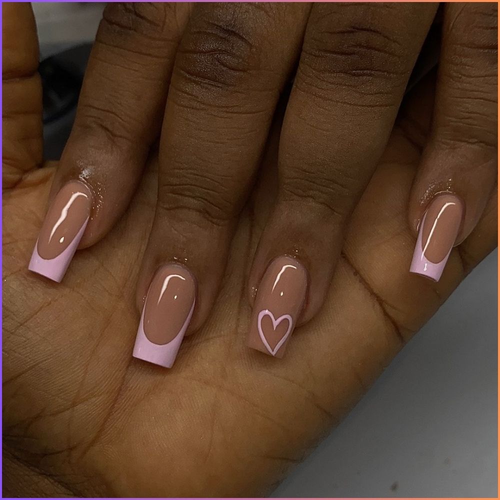 Zoom in view of hand with simple French tip nail having Cute pink tips with heart