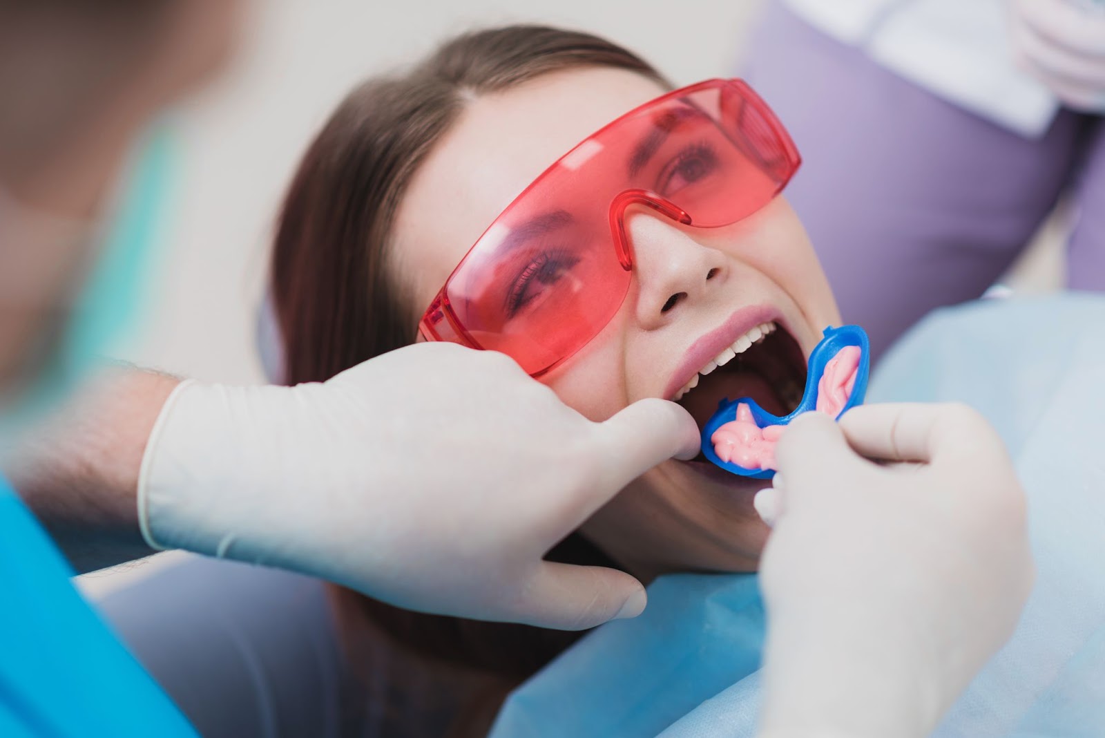 A dental hygienist performing a fluoride treatment on a young lady.