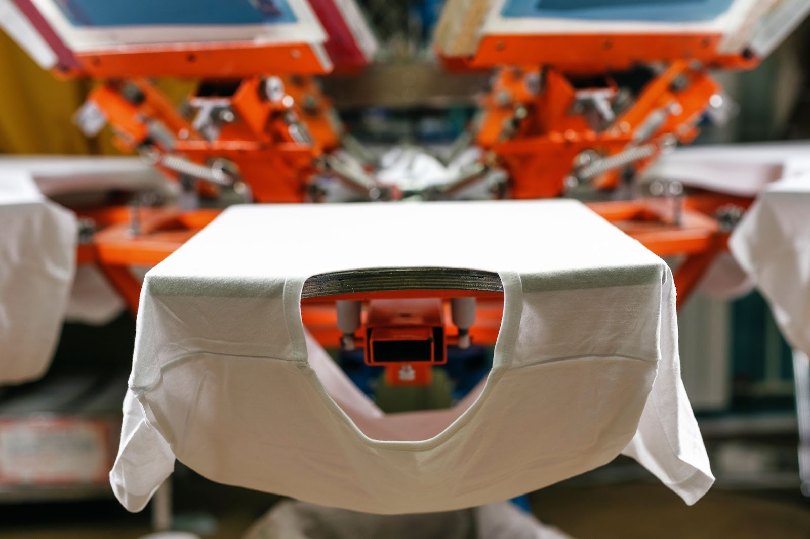 A detailed view of the hands-on screen printing process used to create high-quality custom apparel.