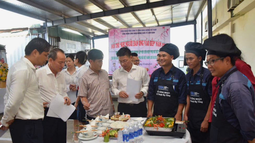 A group of people standing around a table with foodDescription automatically generated