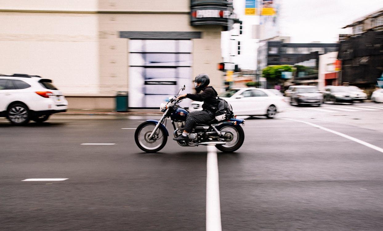 Free Motorcyclist speeds through a busy city street in San Francisco, California. Stock Photo