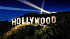 This contains an image of  the hollywood sign is lit up at night