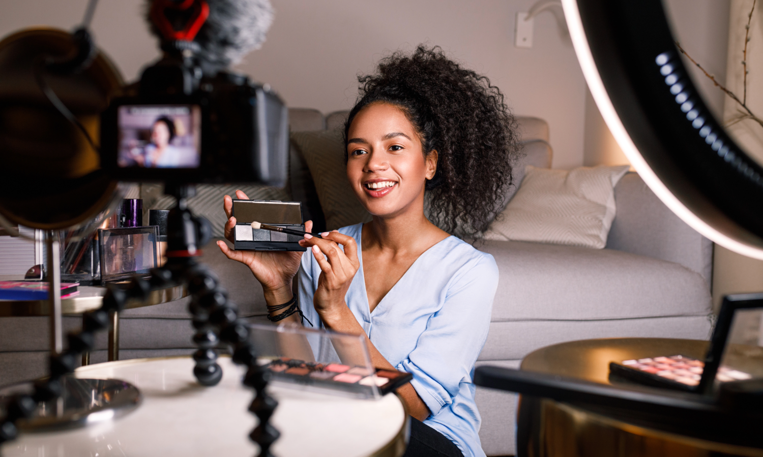 A content creator recording a video while using make up. 