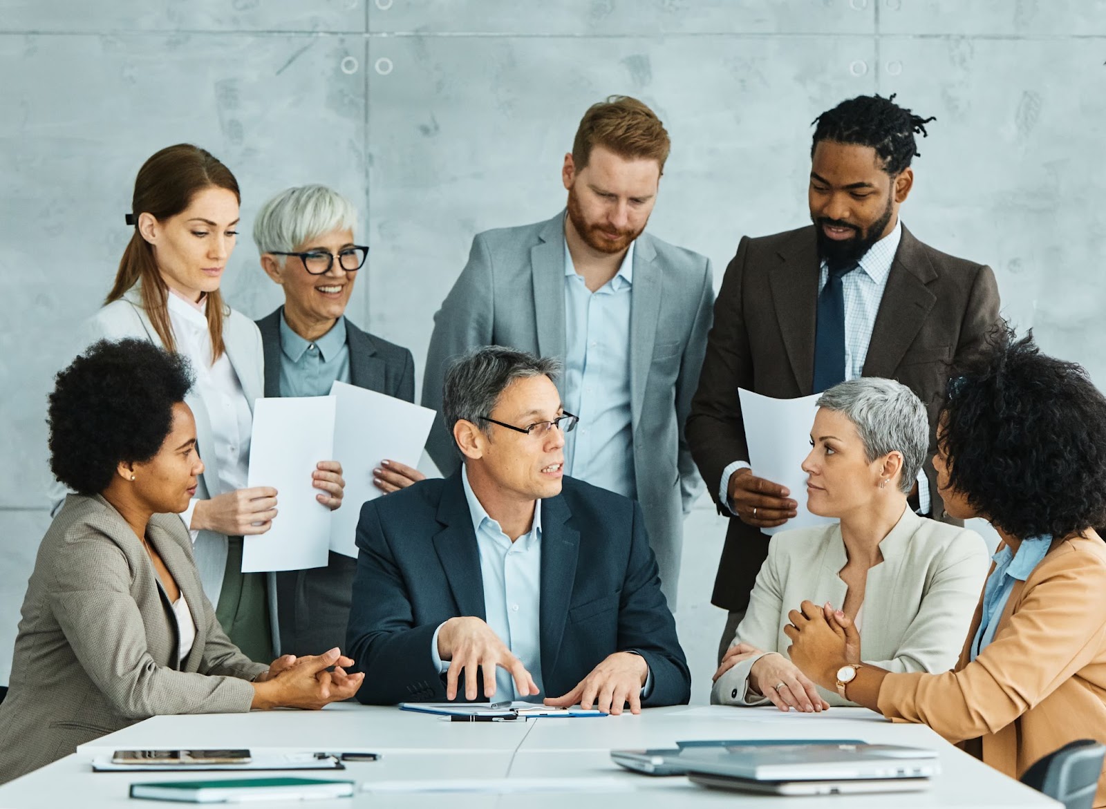 A group of young and senior business people meeting in an office.