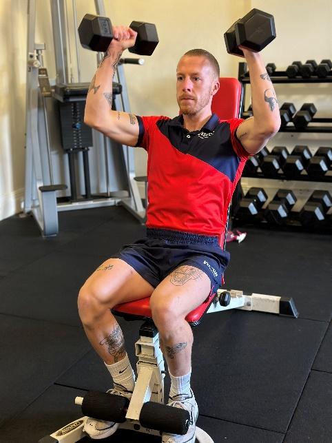 a Vision PT personal trainer doing dumbbell shoulder press