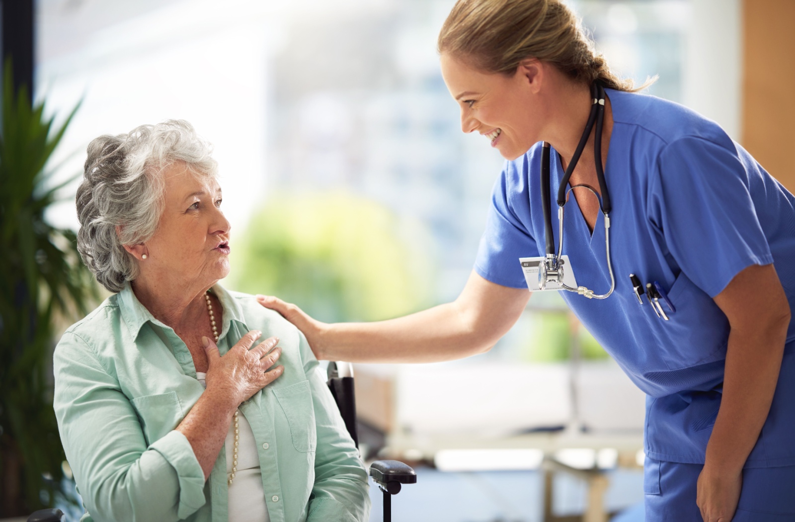 Caregiver smiling while providing compassionate care to a senior