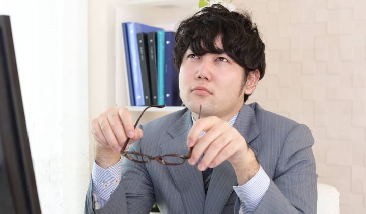 Asian businessman with eyestrain