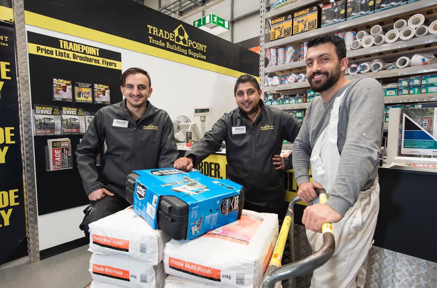 A group of men standing next to a stack of boxes Description automatically generated