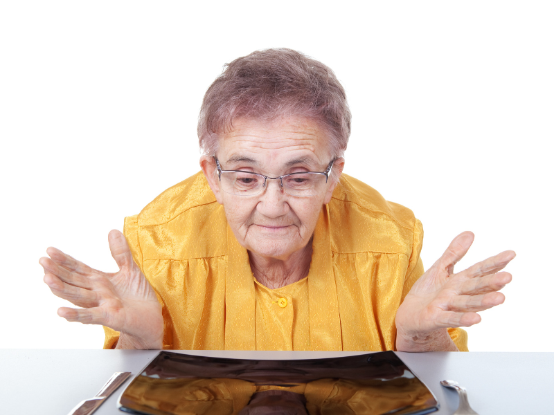 women staring at a plate with no food