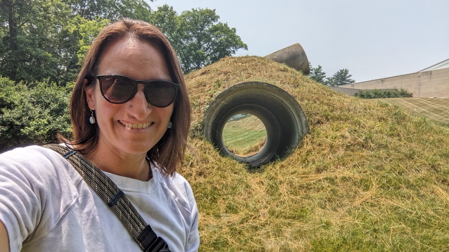 Image of Associate Professor of Art History Annie Dell'Aria in front of Star-Crossed Sculpture by Nancy Holt. 