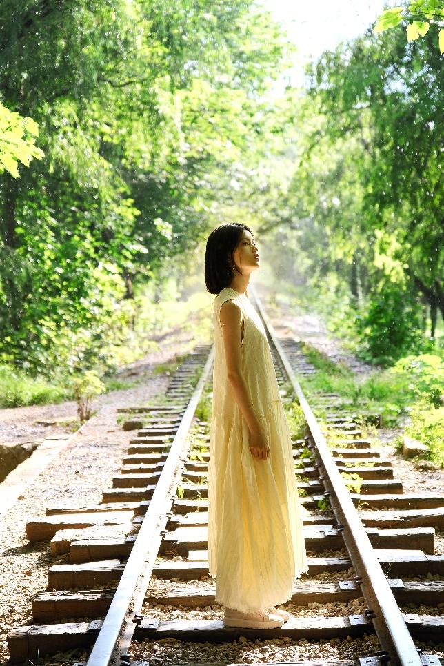 A person standing on train tracks

Description automatically generated