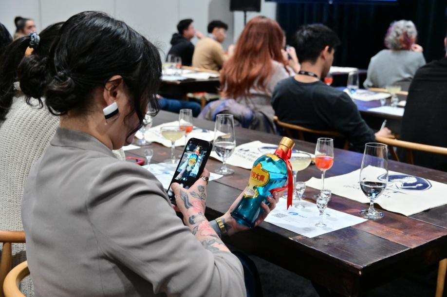 A person holding a bottle of alcohol

Description automatically generated