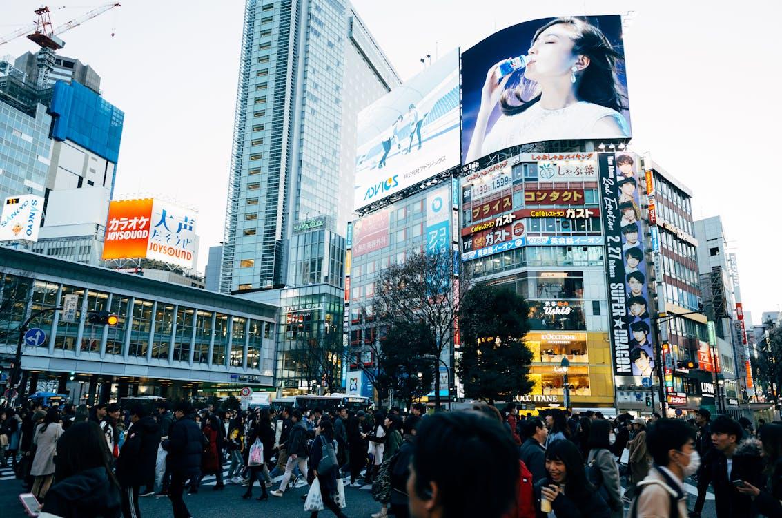 Free Vibrant nighttime view of the iconic Shibuya Crossing in Tokyo, full of neon lights and bustling crowds. Stock Photo