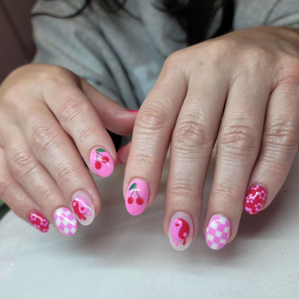 Close up of flowered short nail design with Cherry with flower on light pink nails