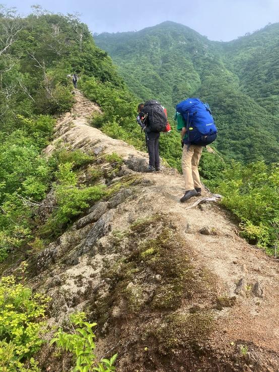 山の中の道を歩いている男性

自動的に生成された説明