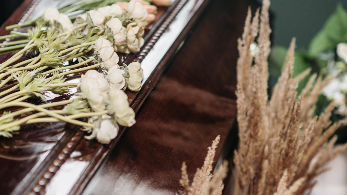 brown casket with flowers