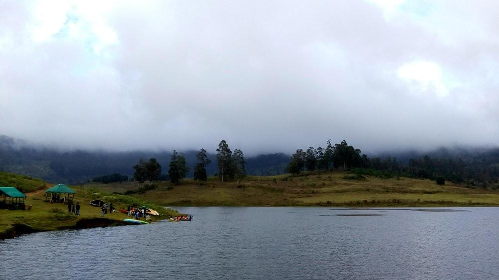 people camping beside body of water during daytime