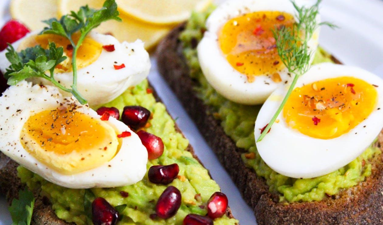 Free Savor this delicious avocado toast topped with soft-boiled eggs and garnished with pomegranate seeds. Stock Photo