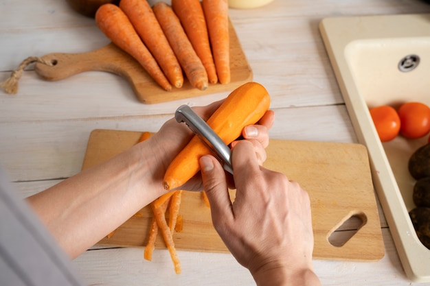 A person peeling carrots in the kitchen