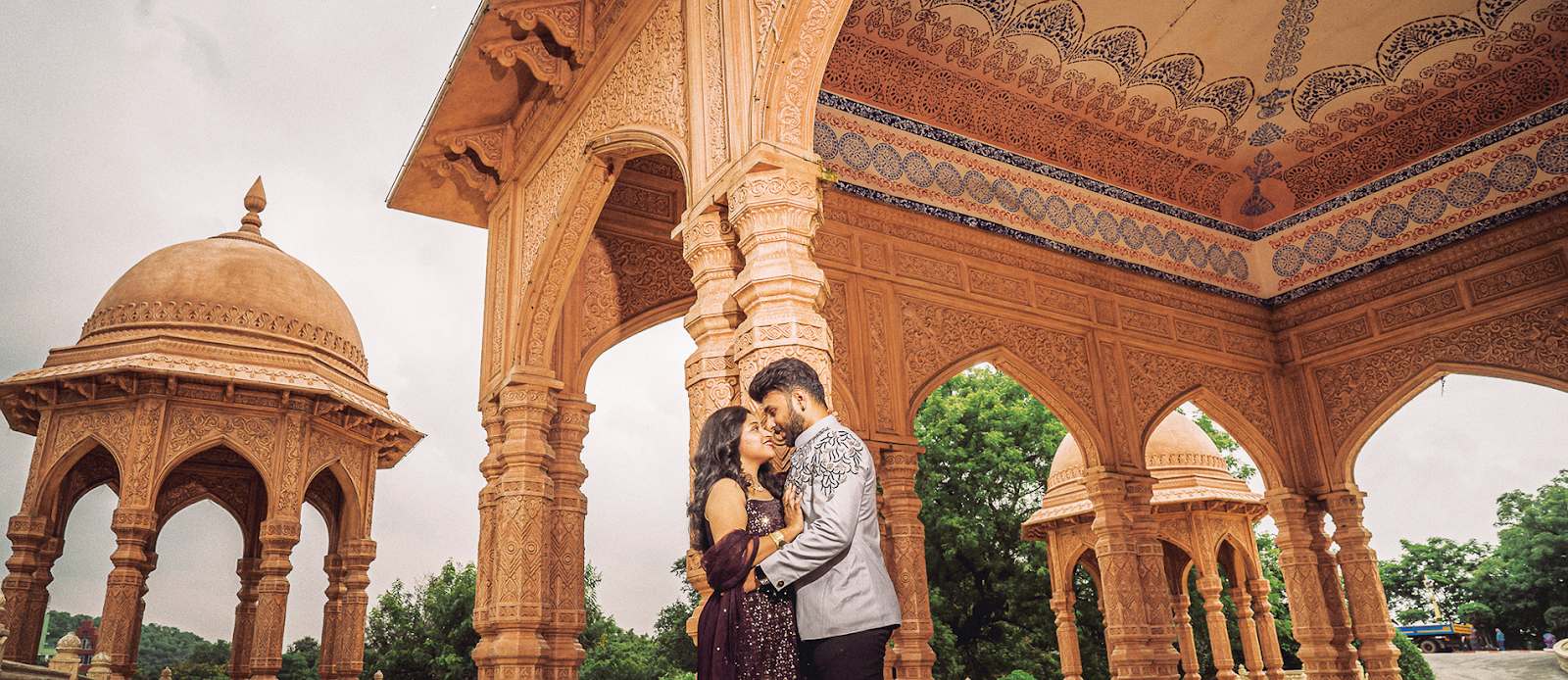 Elegant pre-wedding photoshoot of a couple in a loving embrace at a historic fort