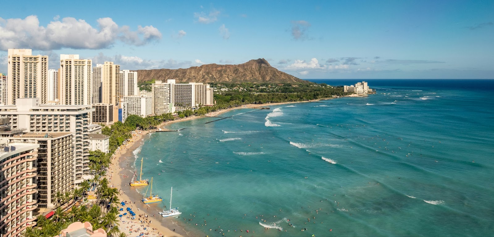 Waikīkī Beach with turquoise waters, golden sand, and luxury resorts in Honolulu.