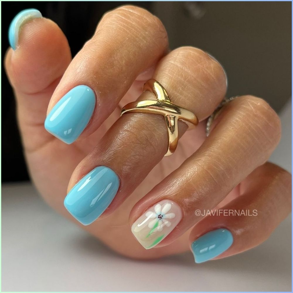 Close up of flowered short nail design with blue flower nails