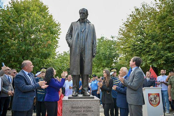 A group of people standing around a statue

Description automatically generated