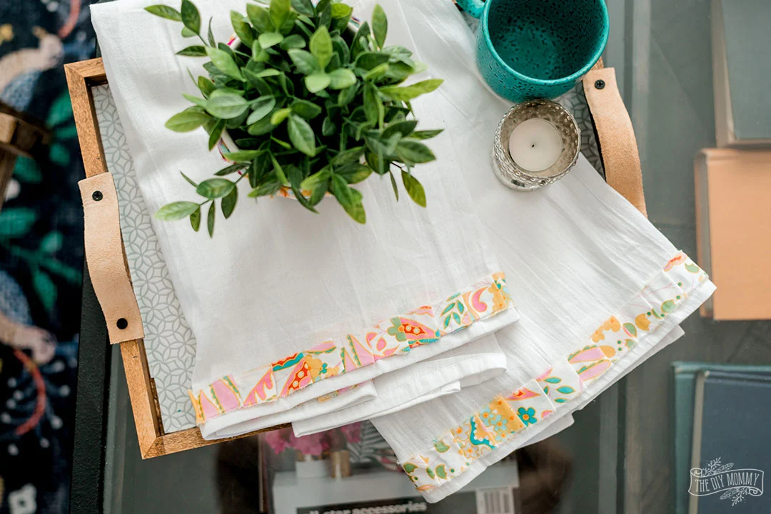 white tea towels accented with ruffled contrast fabric on a wooden table