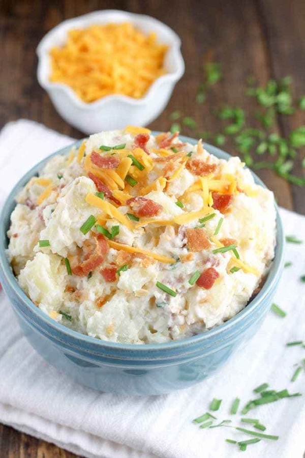 Loaded bake potato salad in a blue serving bowl