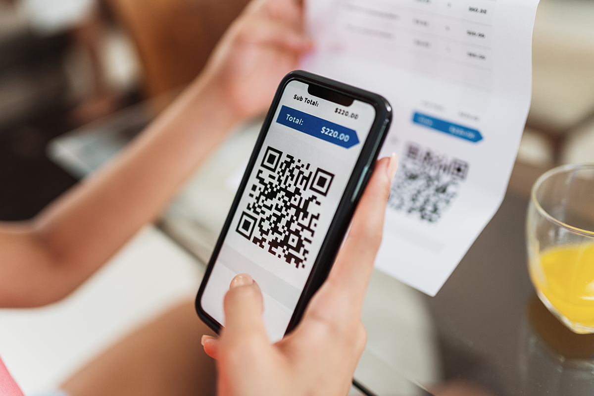 A person holding a phone with a qr code on it

Description automatically generated