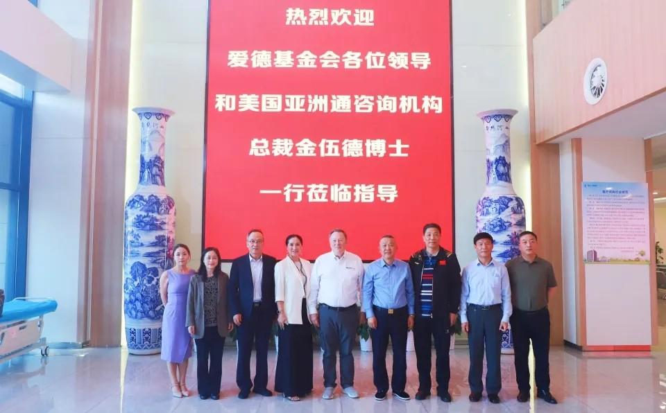 A group of people standing in front of a large sign

Description automatically generated