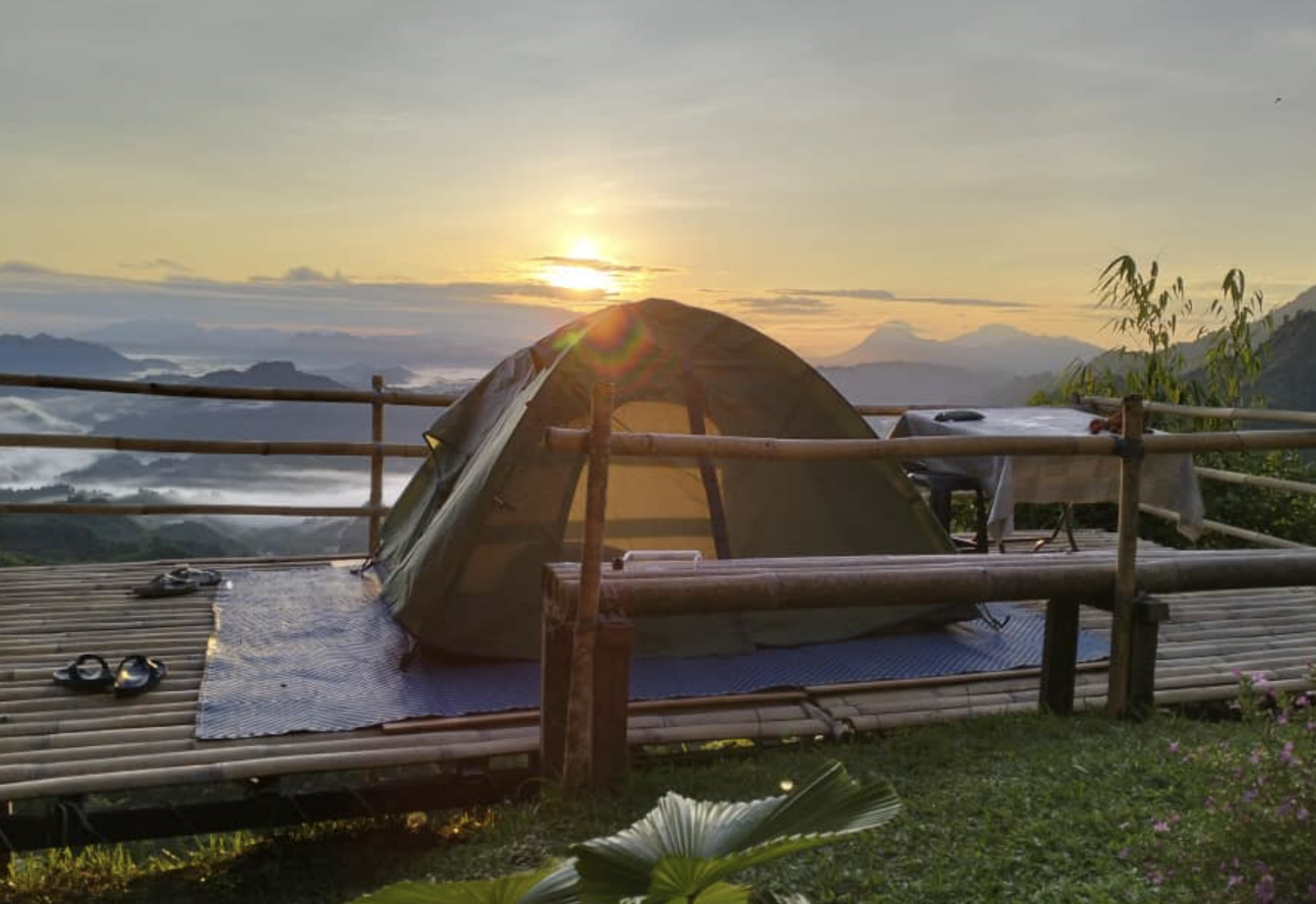 A tent on a deck with a railing and a sunset

Description automatically generated