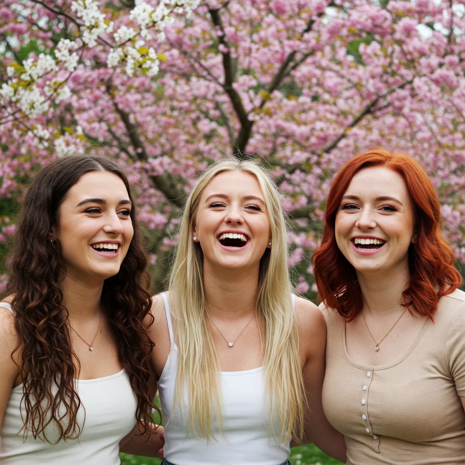 Three young women with cherry blossom trees in the background (no filter)