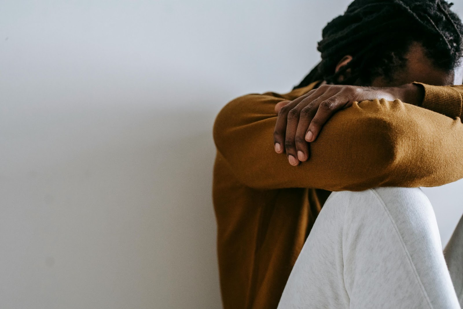 Man sitting with his head resting on his arms