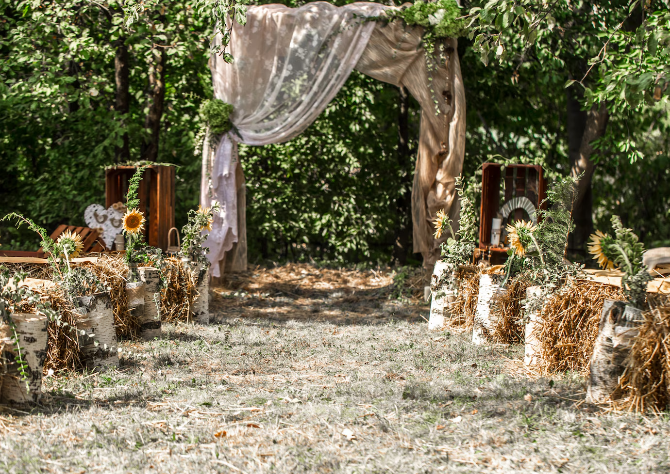 Romantic outdoor gazebo decorated with seasonal flowers and drapes for a dreamy wedding ceremony under the open sky.
