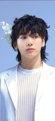 This contain BTS's Jungkook  wearing a white suit and flower in his hair