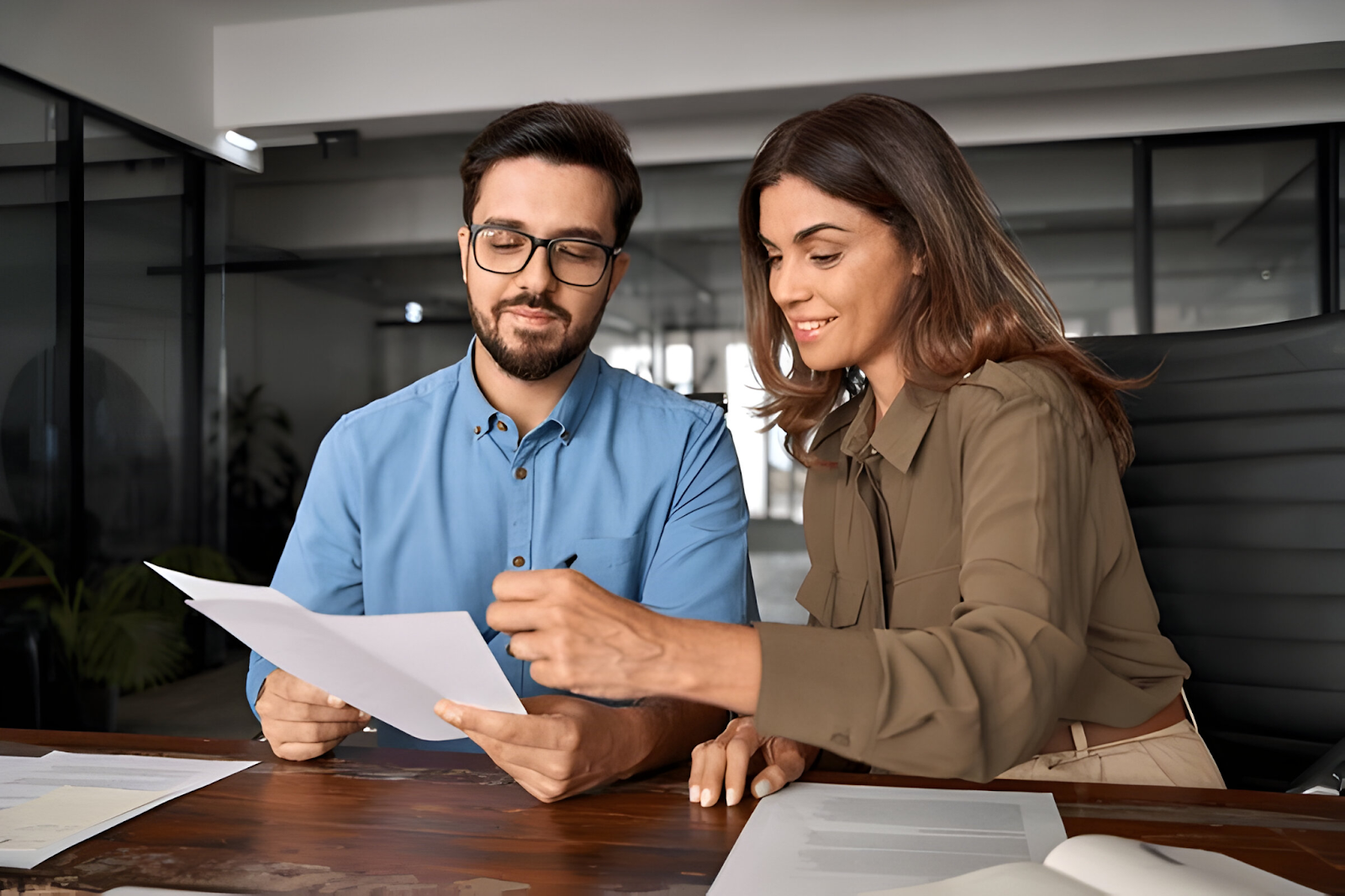 Accountants discussing and reviewing documents to handle international tax issues in a modern office setting.