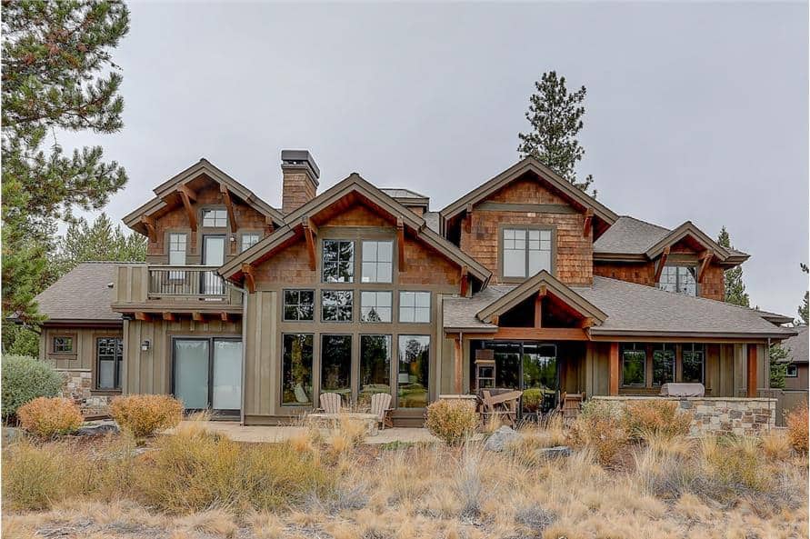 Rear exterior view with large windows, covered porch, and open patio.