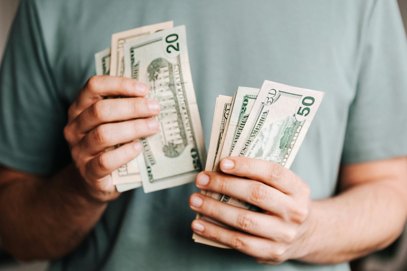 A man holding cash in his hand for a perfect travel fund. 