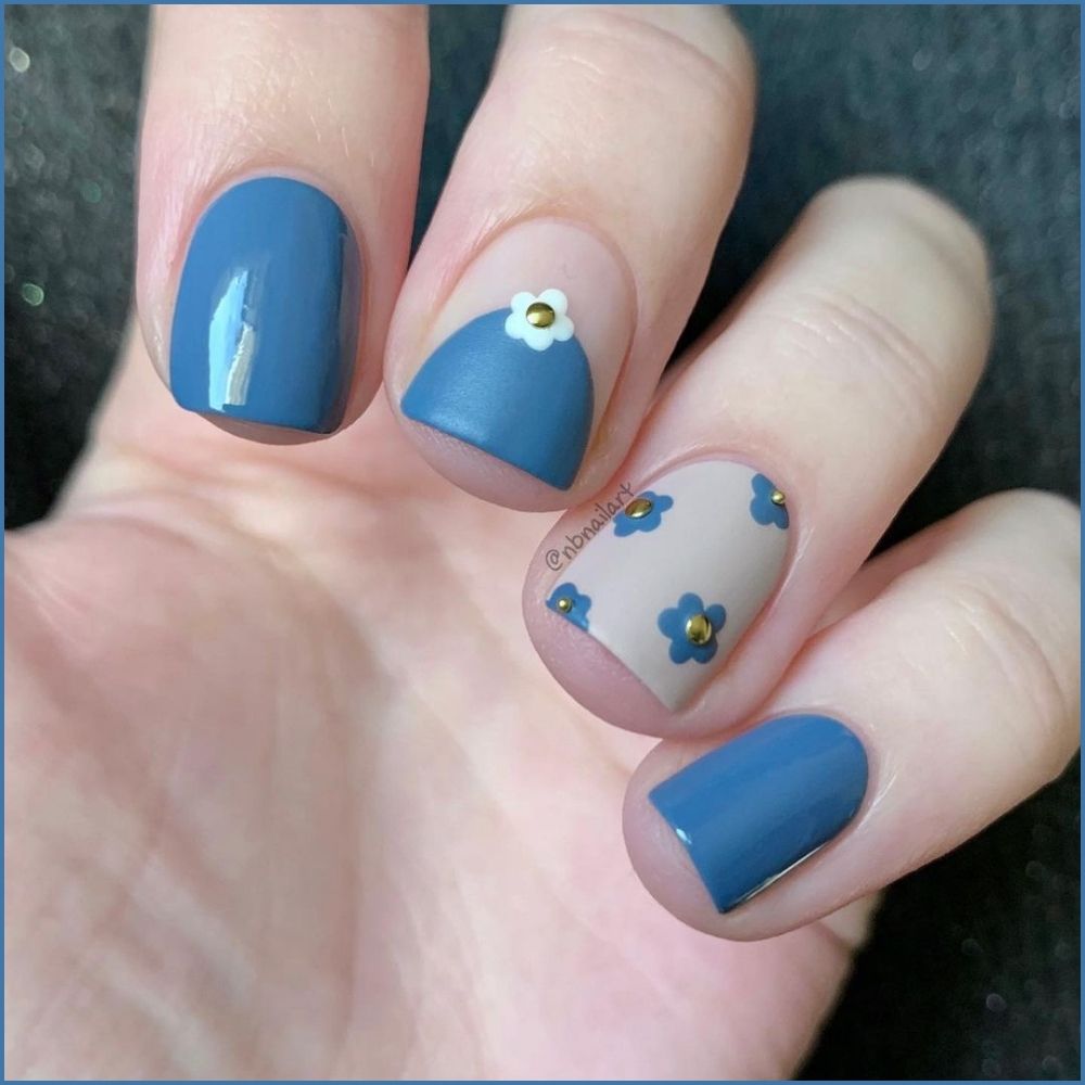 Close up of hands with flowered designed blue nails having Half Moon Designs with Tiny Flowers