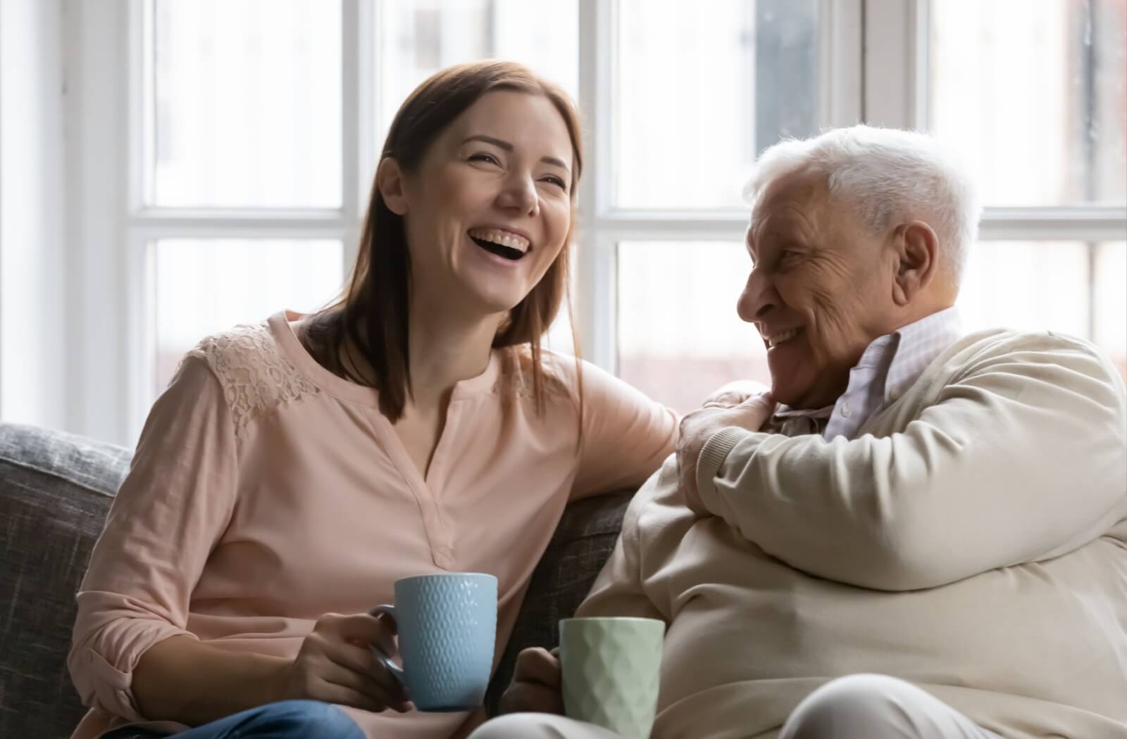 An adult child and their parent have a happy conversation together about future plans for senior living and respite care options.