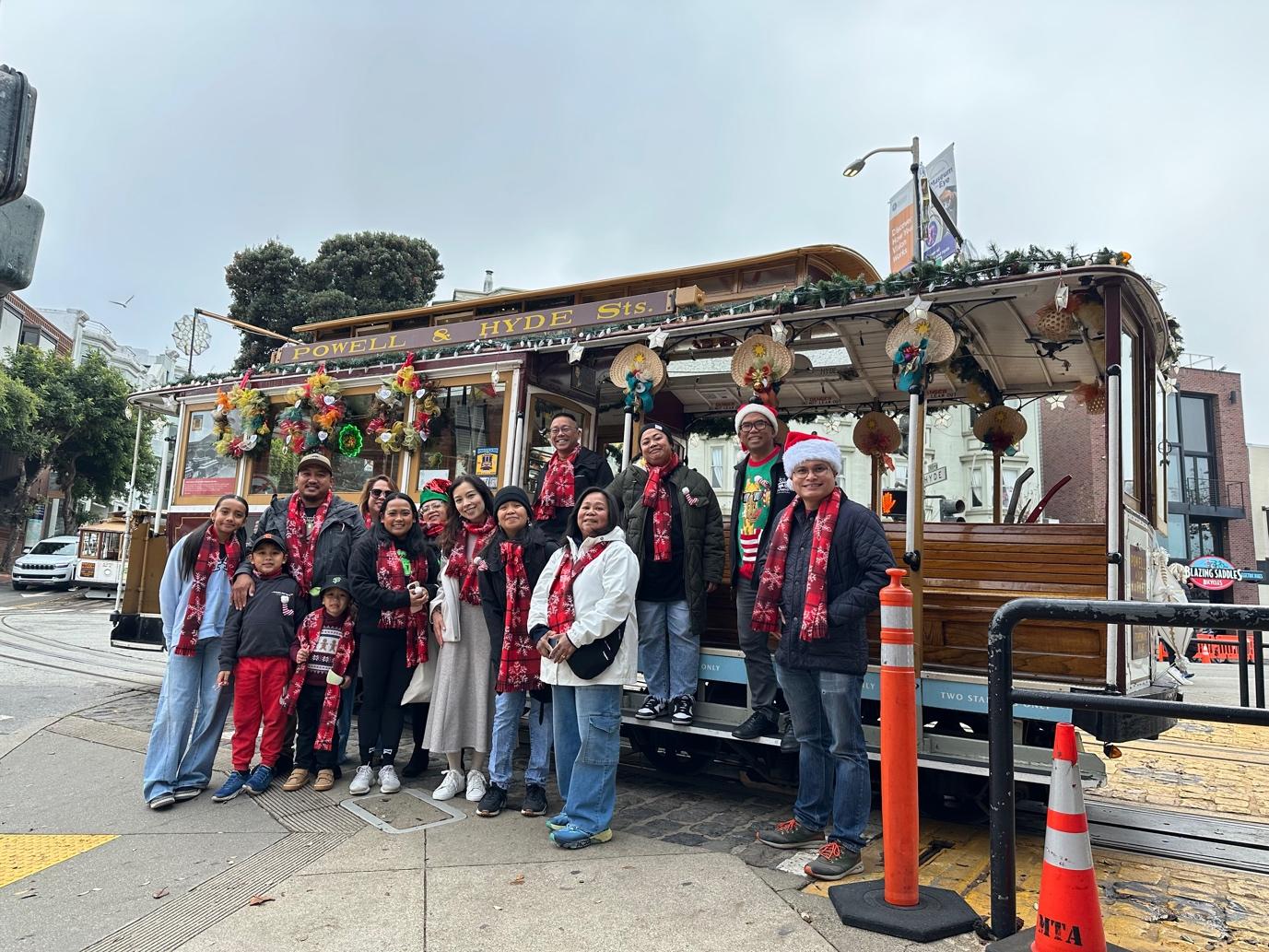 A group of people standing in front of a trolley

Description automatically generated