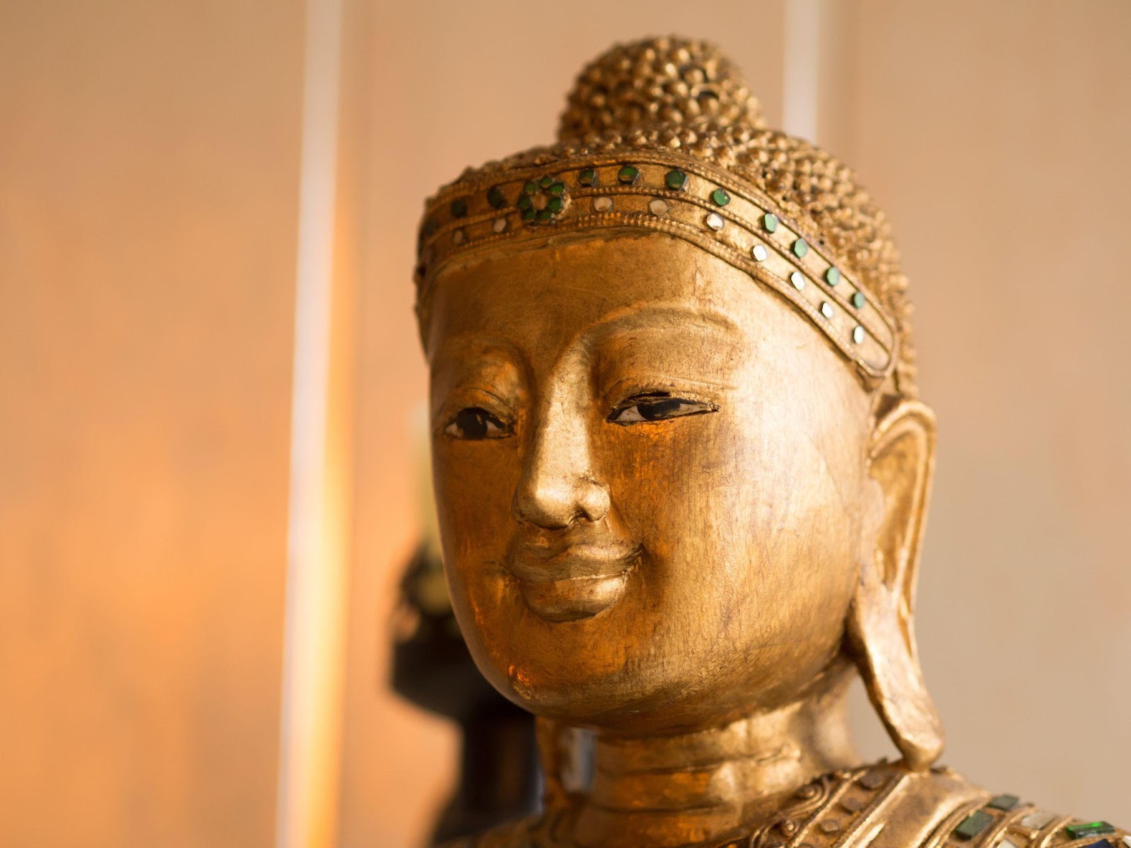 a golden statue of a smiling Buddha