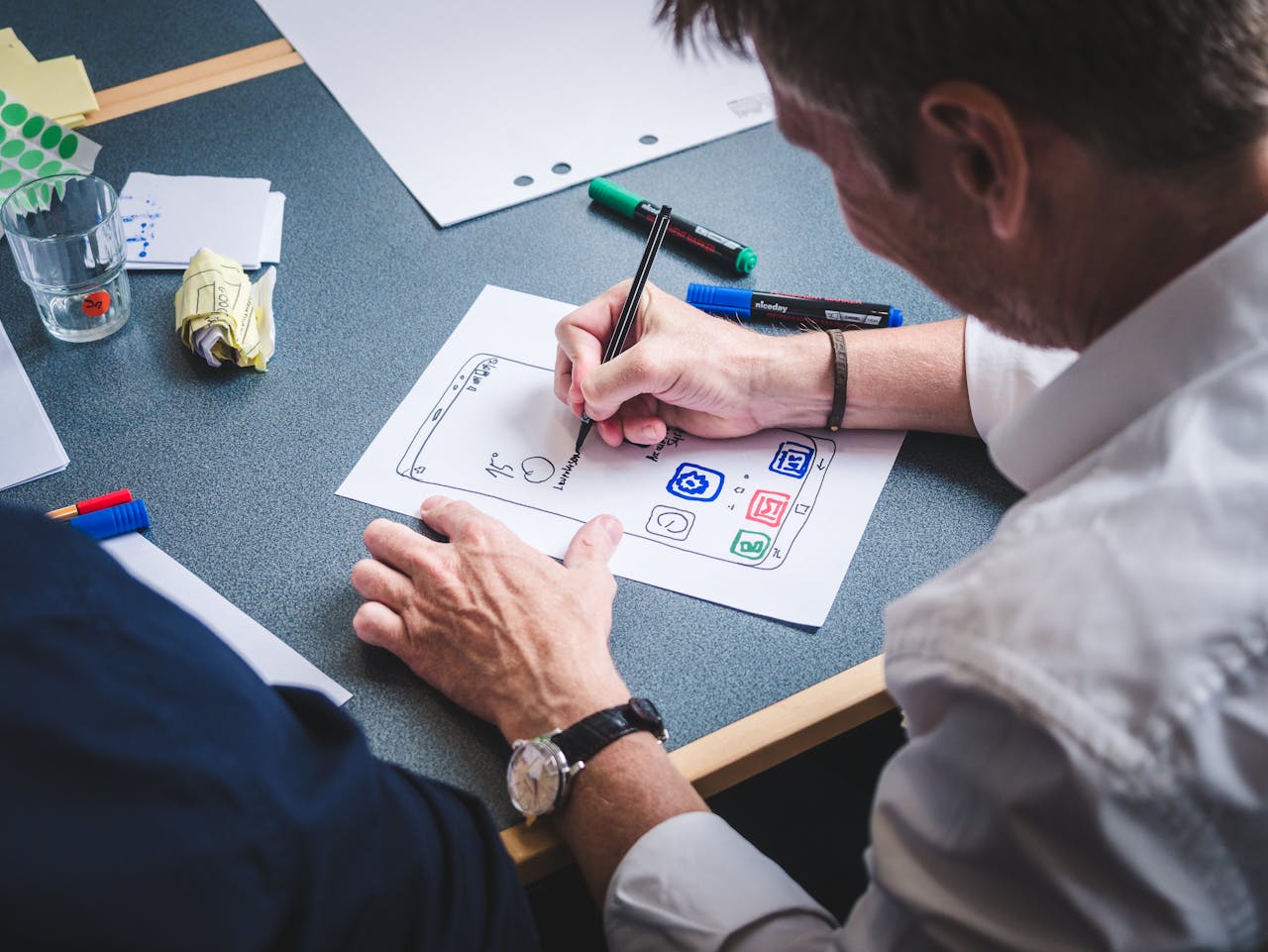 A man drawing a plan on how to use wireframe tools