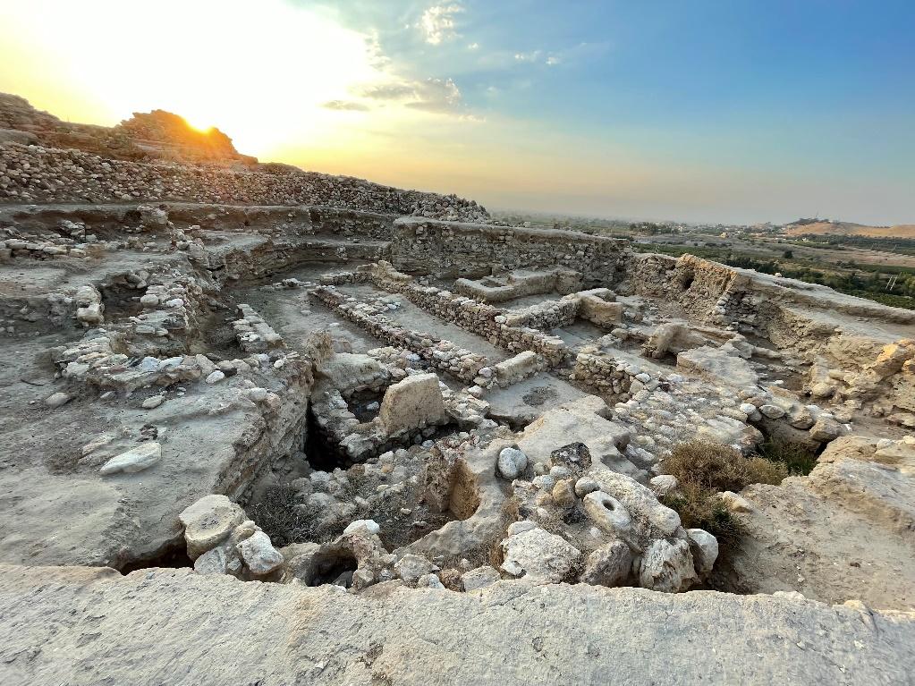 A sun setting over a rocky area

