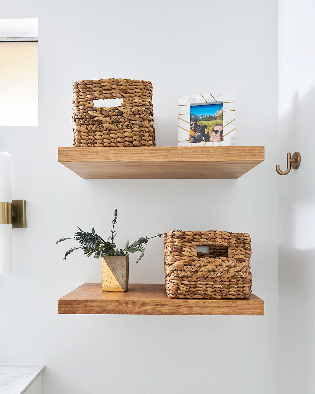 Floating shelves in a bathroom, featuring baskets for storage