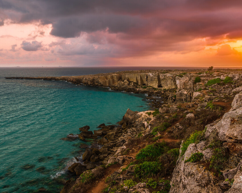 Sicily with a pink and orange sky.