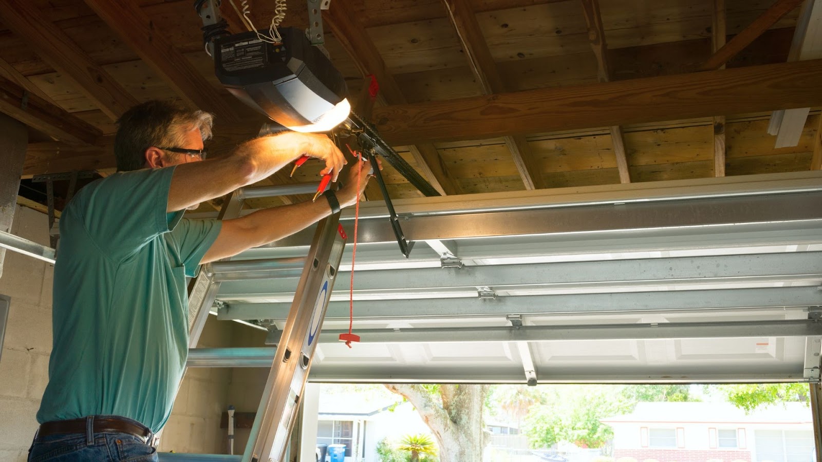 A technician works on the garage opener to fix persistent problems.