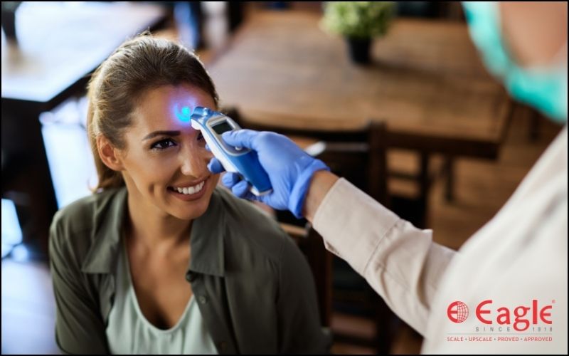 temperature checking of a woman through infrared thermometer