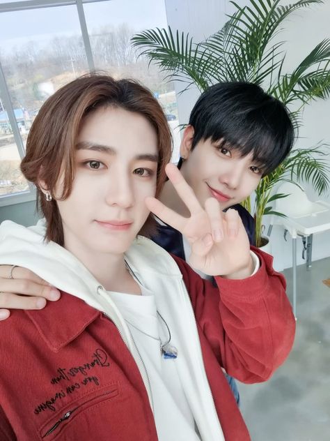 This contain an image of aehyun and Leehan posing for the camera in front of a window and one person making the peace sign